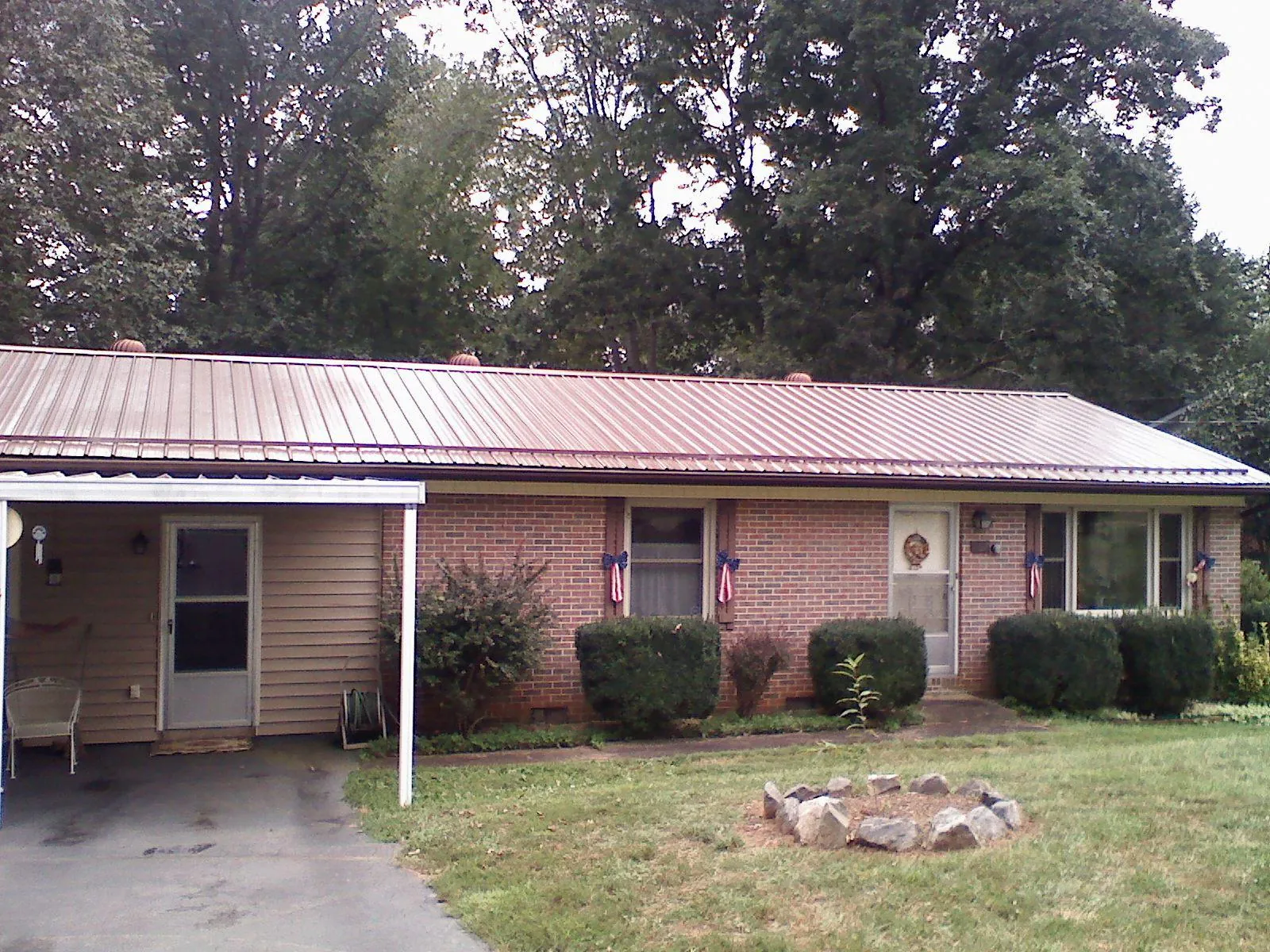 Bronze metal roof and carport on a brick ranch home — Roof Repair work by our crew in Hamlin